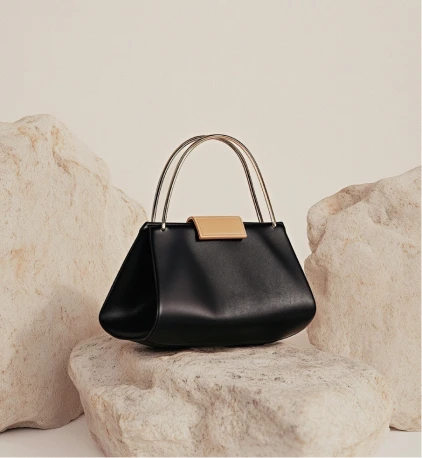 A structured handbag resting on stone
